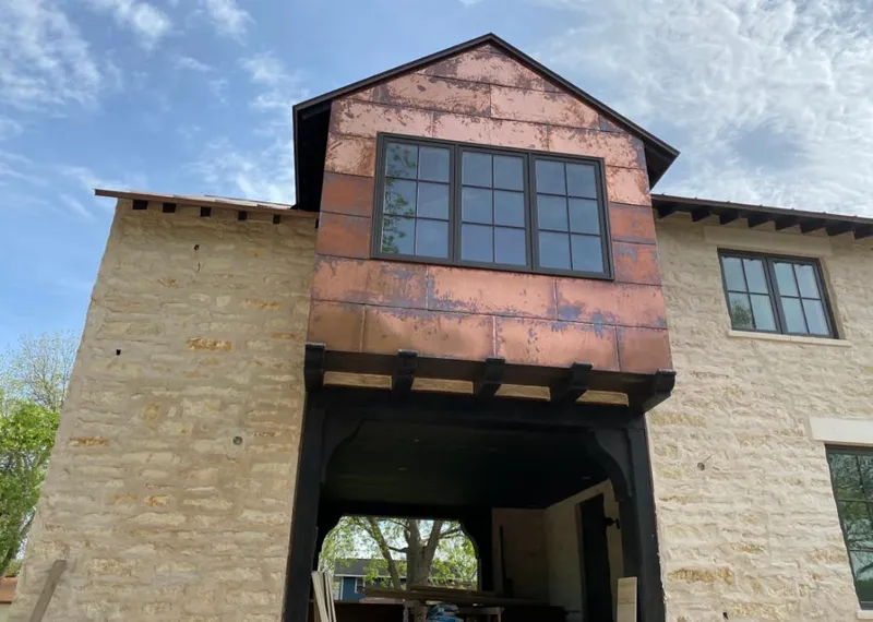 Copper metal panel facade on a stone building for Roof Repair in Avon